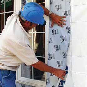Contractor installing Protecto Wrap waterproofing membrane around a window